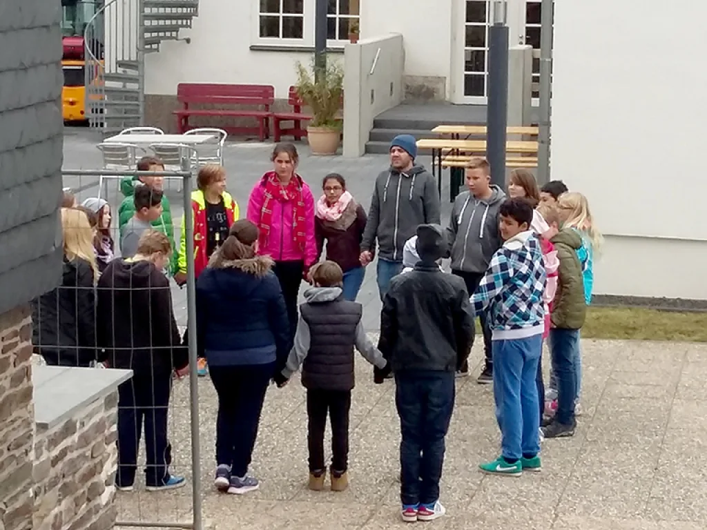 Jugendliche stehen bei einer Übung im Kreis.